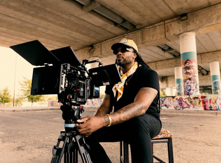 Man with camera under a bridge with graffiti