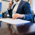 a man sitting at a desk writing on a piece of paper