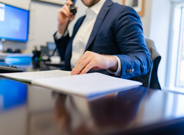 a man sitting at a desk writing on a piece of paper